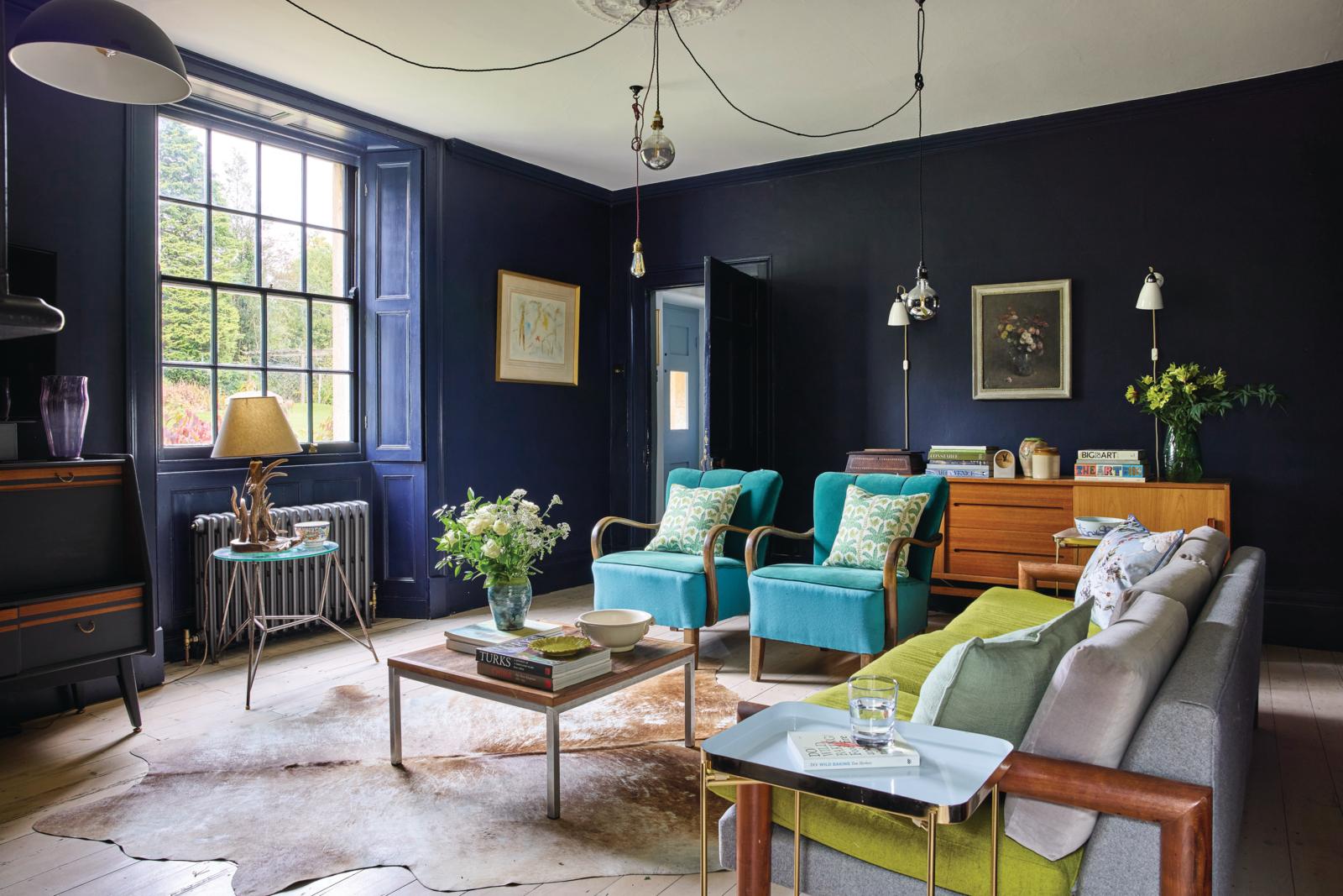 Georgia and Neal love the juxtaposition of the mid-century furniture, including a pair of Jindrich Halabala armchairs, with the Georgian features in the sitting room, which is painted in the striking deep blue Plimsoll by Paint & Paper Library.