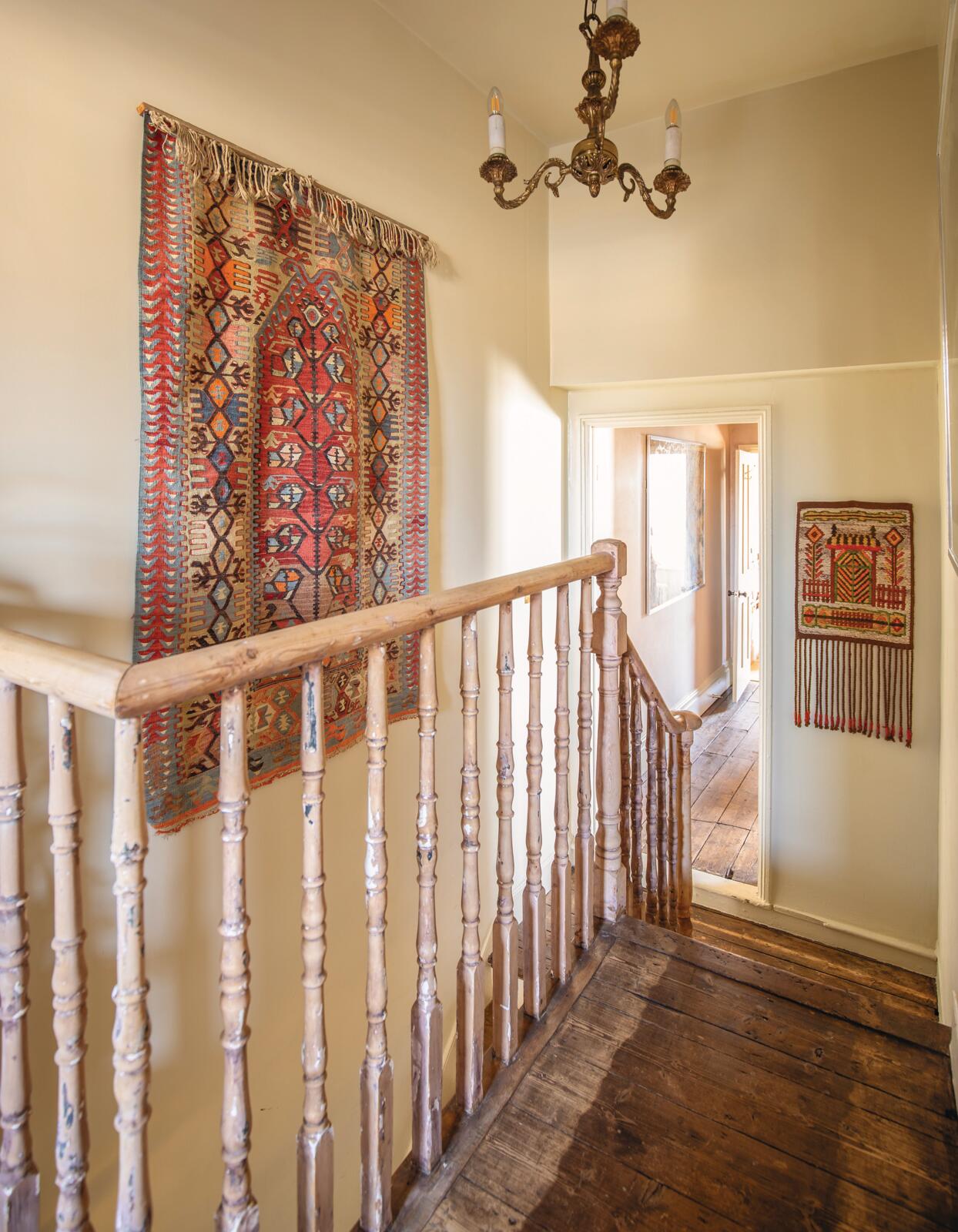 A wall-hung kilim adorns the landing wall